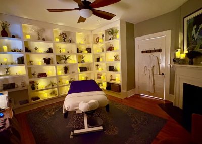 Treatment room with candlelit apothecary shelves
